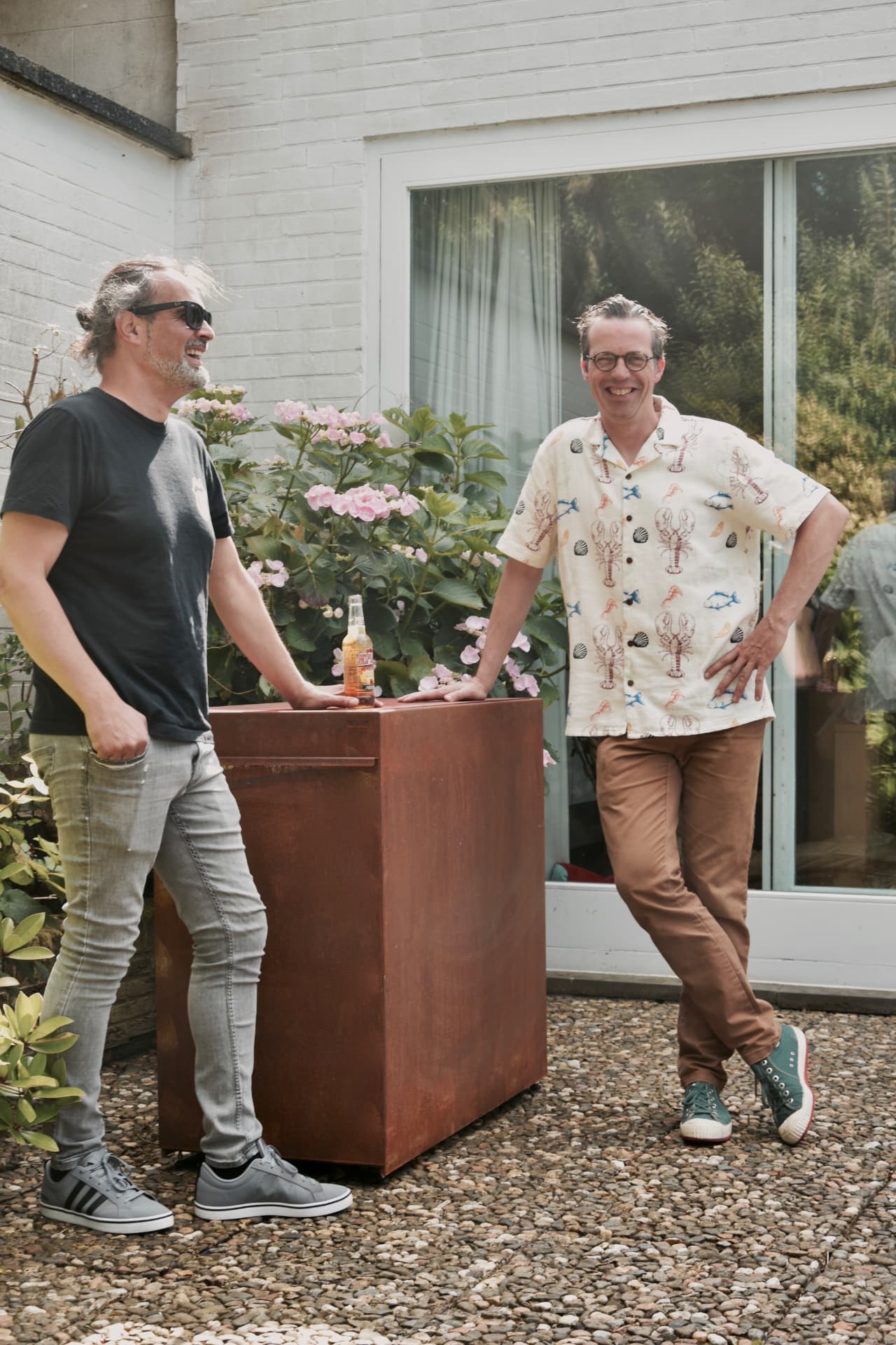 Twee mannen in gesprek aan een KUJP Standaard met een glas op het blad