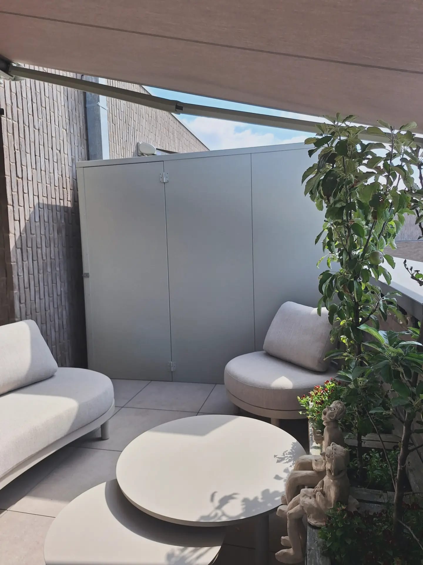 Grijze KUJP kasten op maat als tuinscheiding op een terras