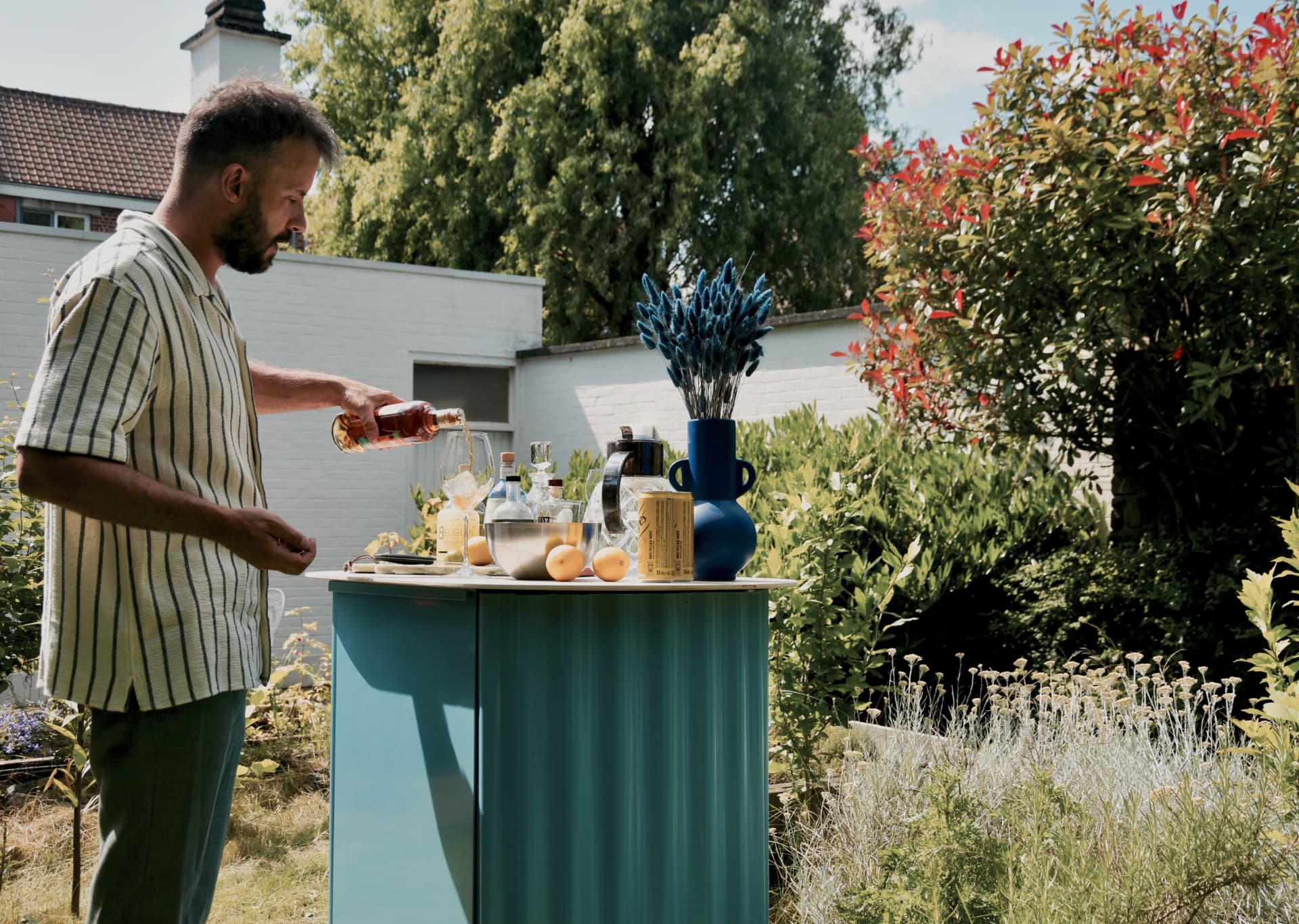 Blauwe KUJP Bar in de tuin, iemand schenkt een aperitief in